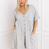 A relaxed grey button-down romper, a stylish choice for vacation clothes or casual chic.